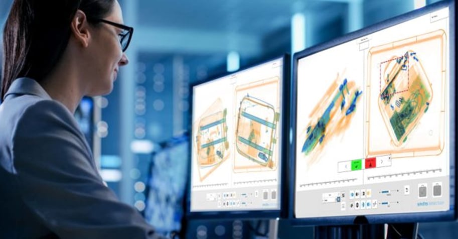 TSA-agent analyseert röntgenfoto's van bagage